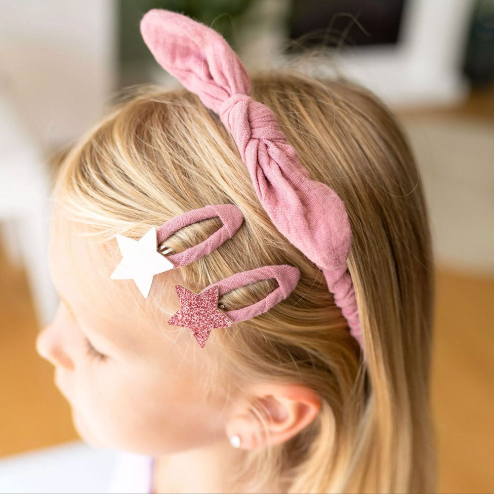 Die Haaraccessoires lassen sich perfekt kombinieren. Zum Beispiel den rosa Haarreifen zu den Spänchen mit Sternen drauf.