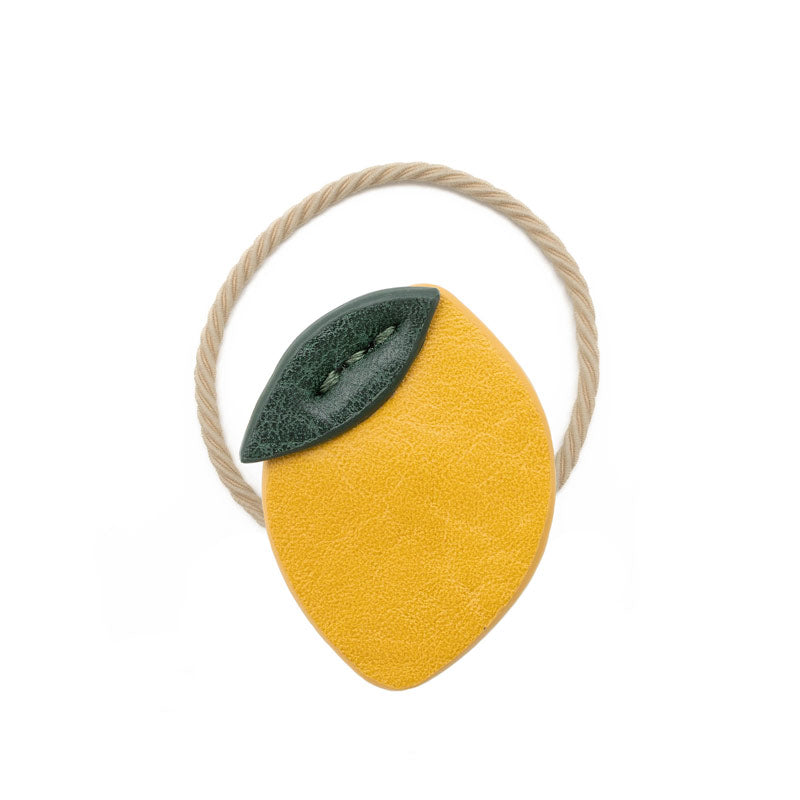 Haargummi Zitrone in gelb mit einem grünen Blatt und einem beigen Gummi