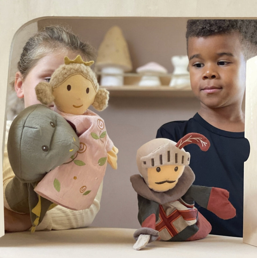 Mädchen und Junge spielen mit der Handpuppe räche, Prinzessin und Ritter in einem kleinen Puppentheater