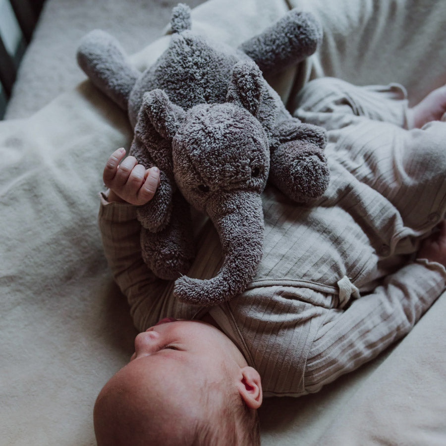 Baby kuschelt mit dem Heartbeat Comforter Elefant in grau