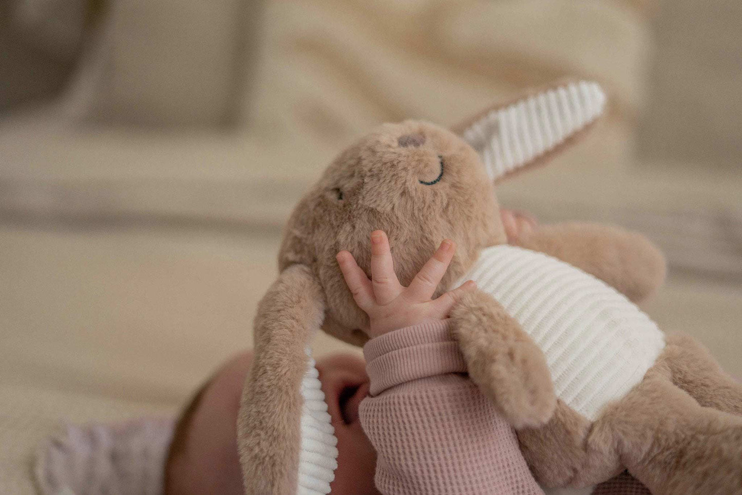 Baby hält den Heartbeat Comforter Hase Milo von Flow Amsterdam