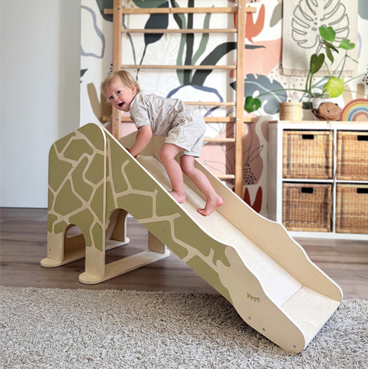 Kind klettert auf der Giraffen-Rutsche von Small Foot im Kinderzimmer