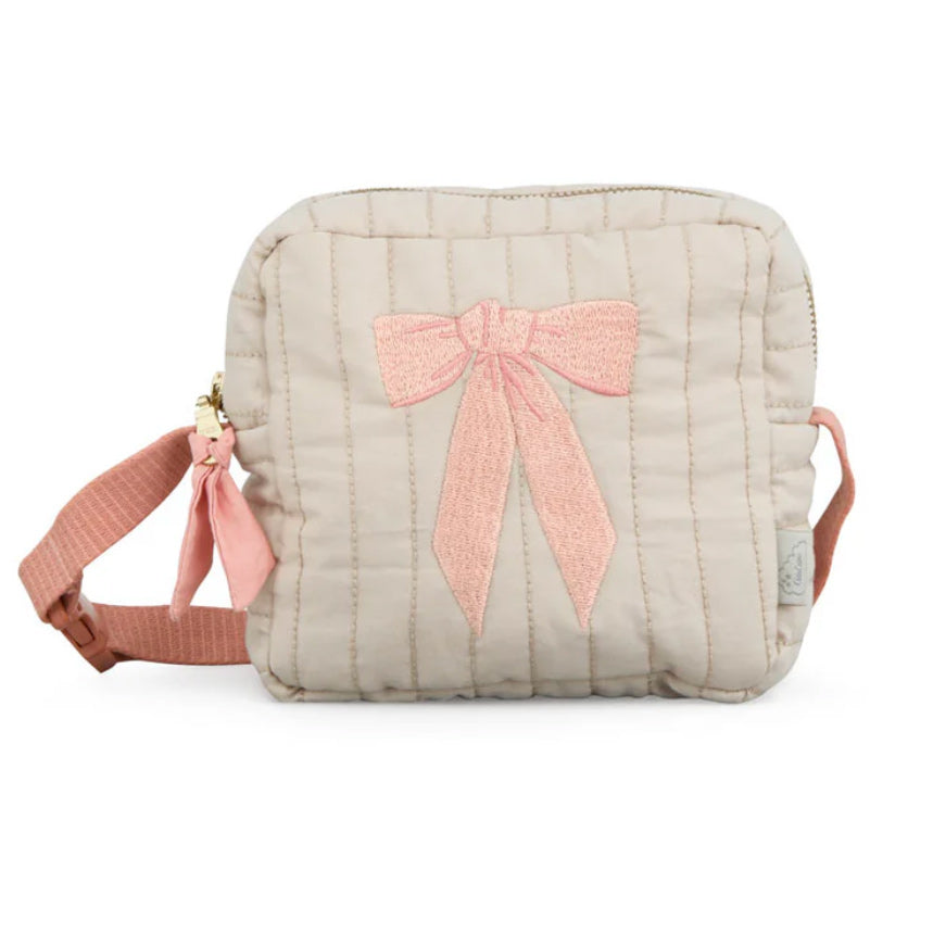 Kindertasche zum Umhängen von Cam Cam Copenhagen in beige mit einer rosa Schleife bestickt und einem rosa Umhängeband.