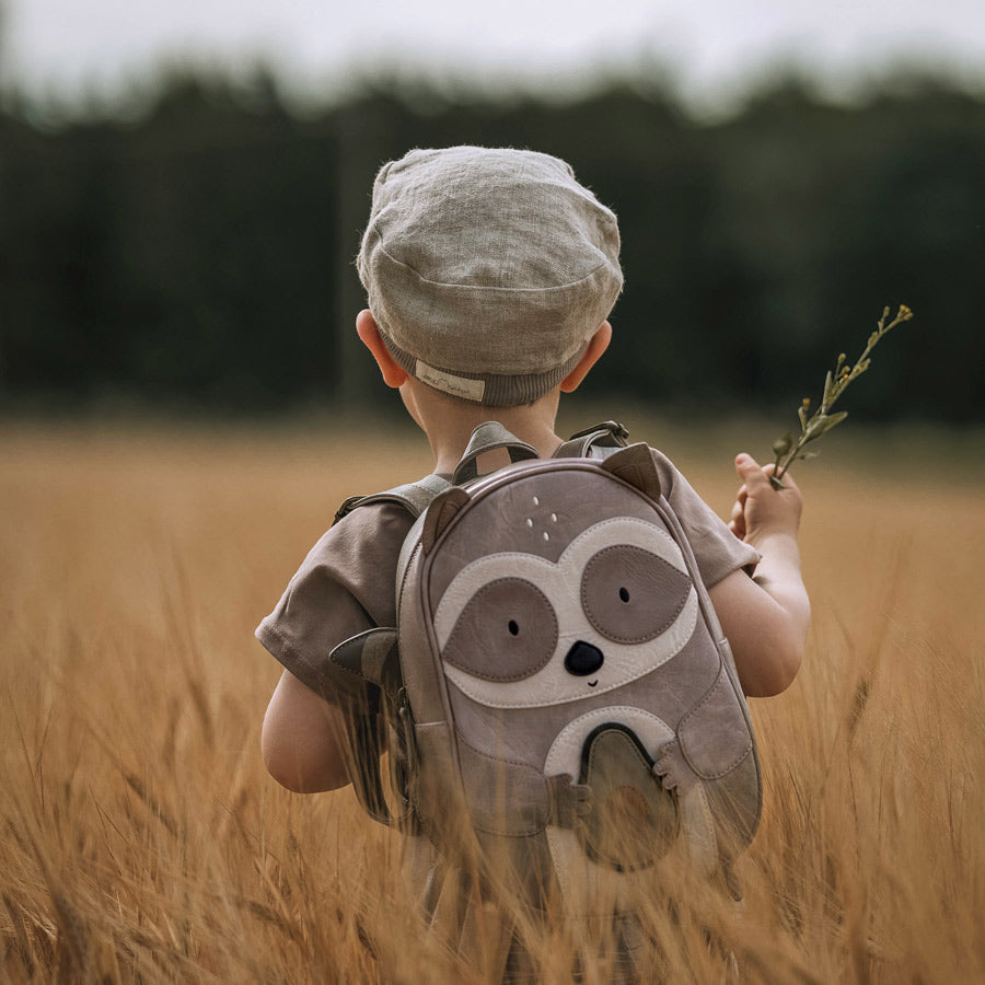 Little Who Rucksack für Kinder mit Waschbär-Motiv in den Farben grau, weiß und einer grünen Avocado