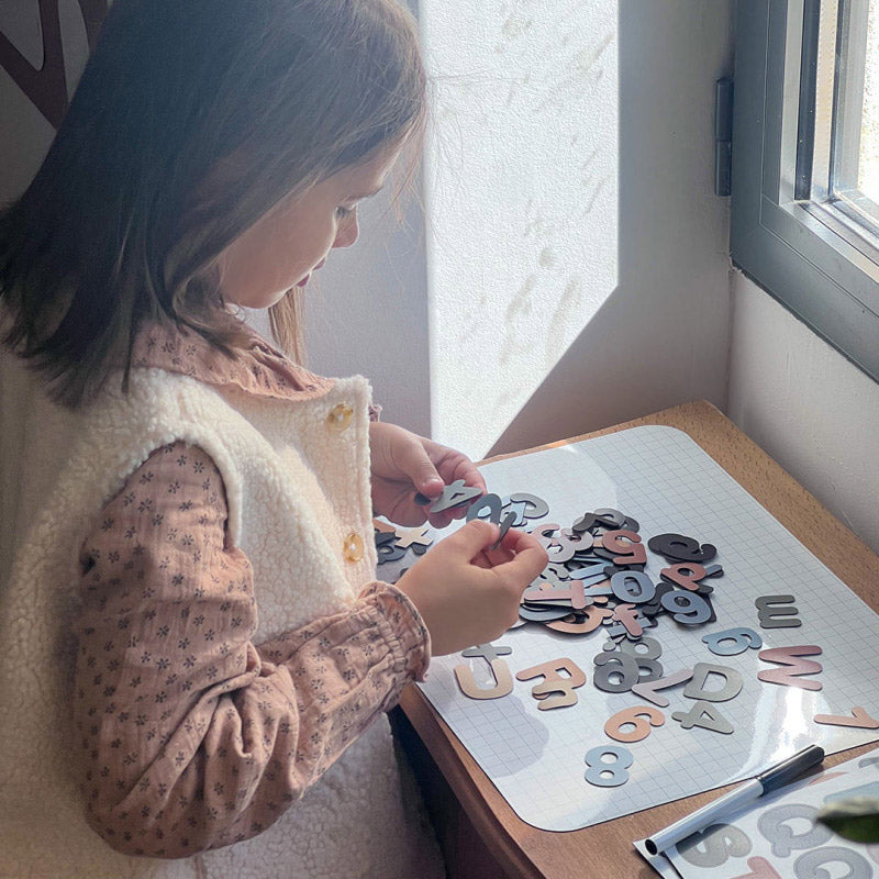 Kind sucht Zahlen und Buchstaben Magnete raus für die Magnettafel von ferflex