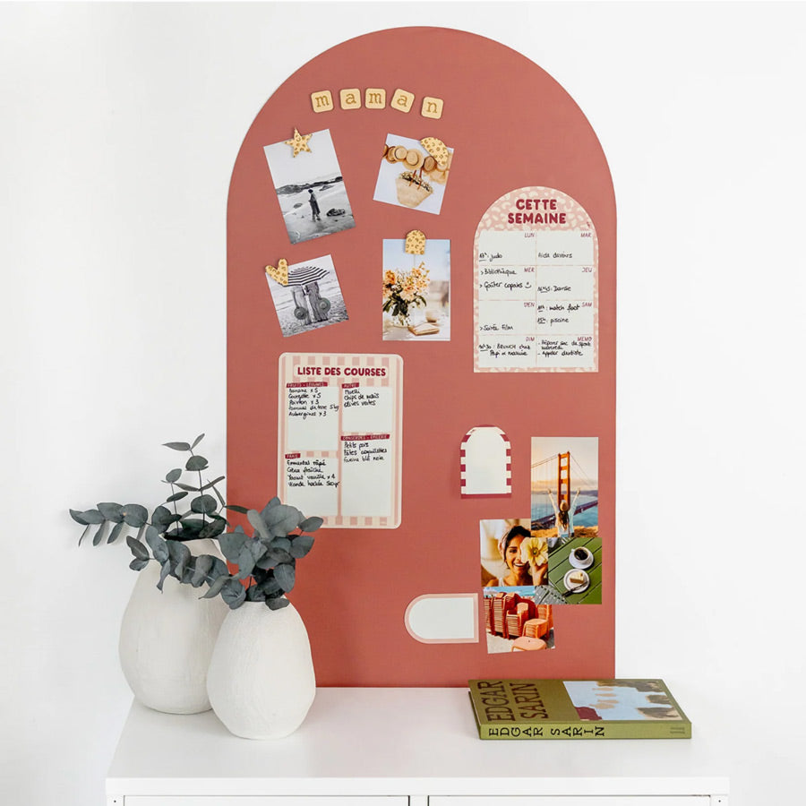 Magnettafel in der Farbe terracotta hängt im Flur mit Fotos, einem Wochenplan und Notizen an der Wand