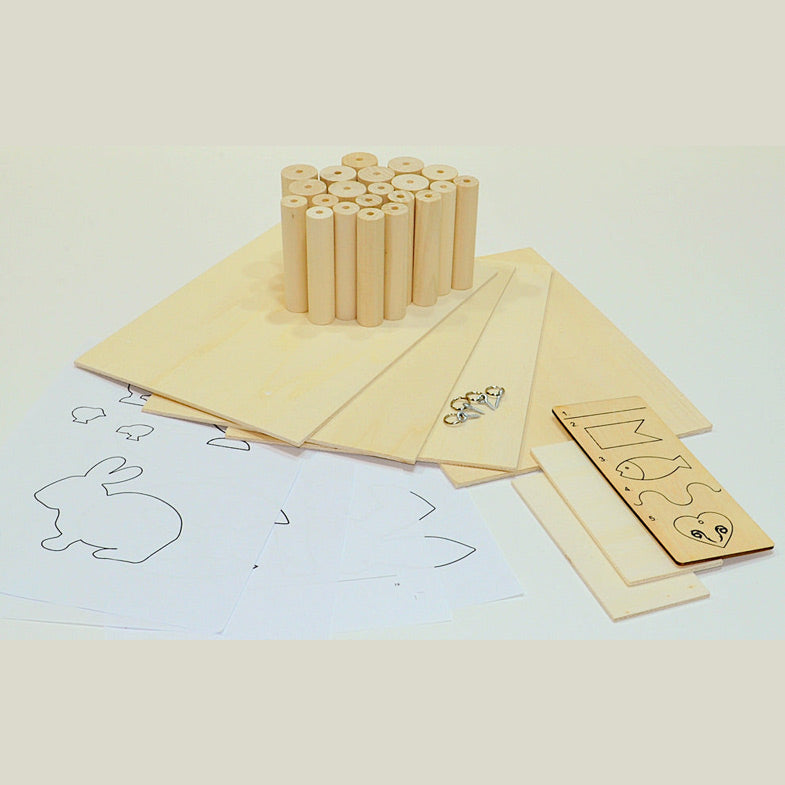 Das Materialpaket mit Vorlagen, Holzplatten, Rundhölzern und weiterem Zubehör zum Arbeiten