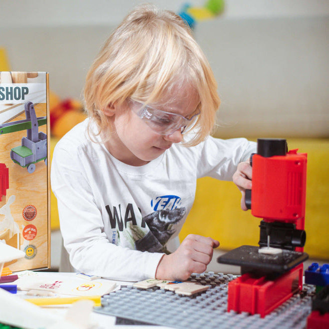 Kind mit Schutzbrille arbeitet an der aufgebauten Bohrmaschine des Multi Tools von The Cool Tools