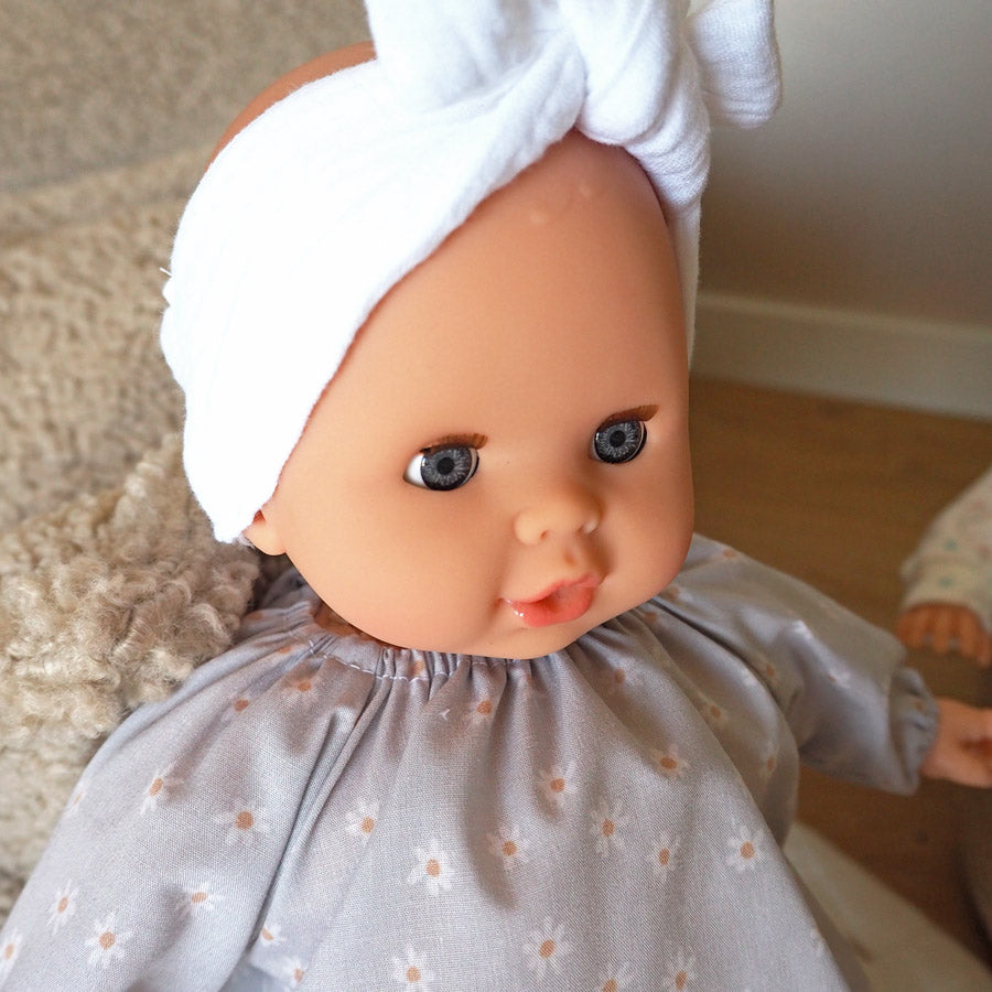 Puppe Daisy hat blaue Augen und trägt ein weißes Stirnband