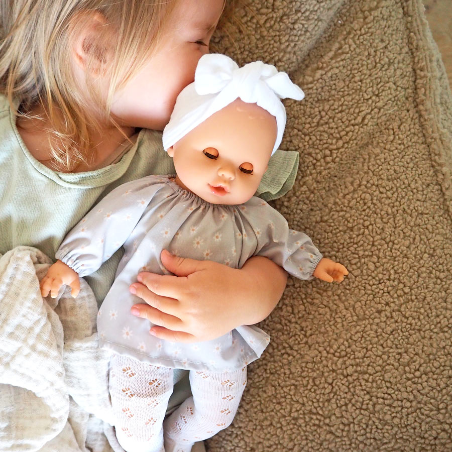 Kleines Mädchen kuschelt mit der Kinderpuppe Sonia Daisy