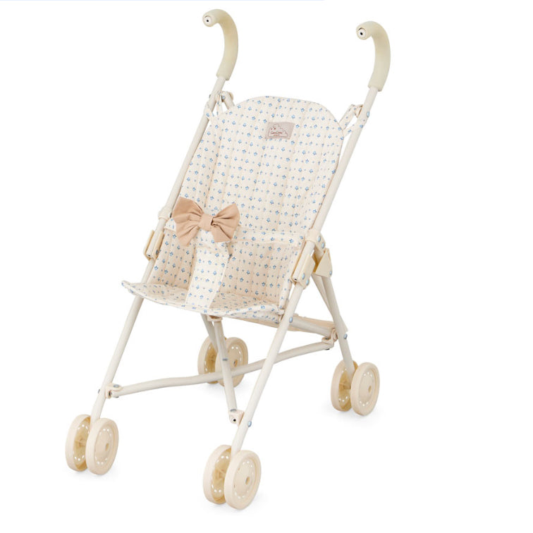 Der Puppenwagen Capri mit einem beigen Design und kleinen blauen Blumenmuster und einer hübschen Schleife vorne.