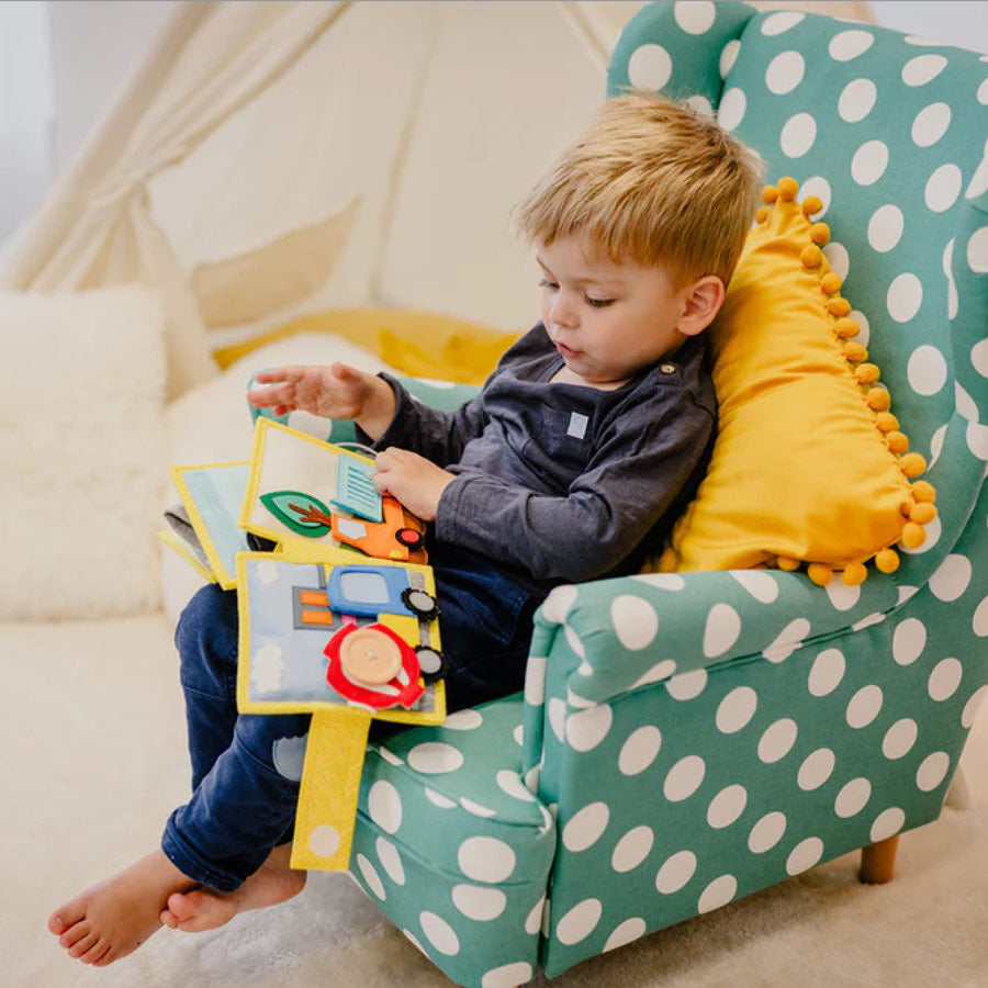 Kleinkind schaut sich das Quiet Book Bagger von Jolly Design an.