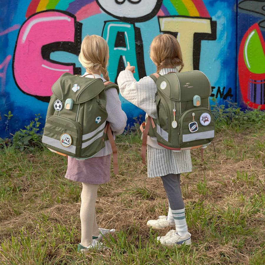 Zwei Mädchen tragen den gleichen Schulranzen in der Farbe grün