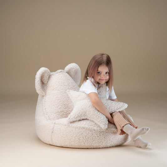 Mädchen sitzt auf dem Teddy Sitzsack für Kinder von der Marke Wigiwama in der Farbe creme