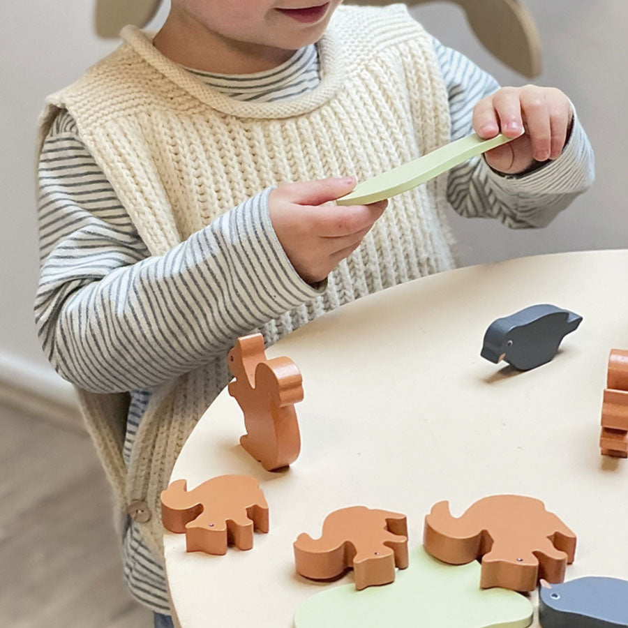 Kind spielt mit dem Balancierspiel Eichhörnchen und Raben