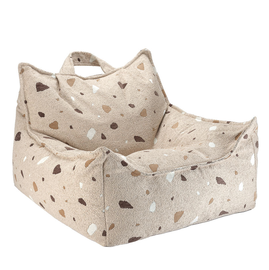 Der Sitzsack von Wigiwama in beige hat geometrische Elemente auf dem Stoff in den Farben weiß, dunkelbraun und hellbraun.