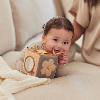 Baby spielt neben der Mama mit dem Aktivitätswürfel von Jollein