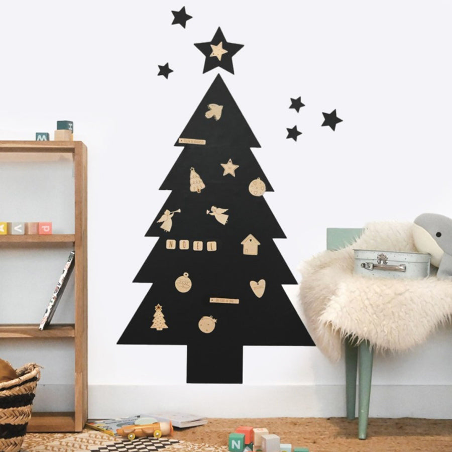 Die schwarze Magnettafel hängt an der Wand mit den verschiedenen Holzmagneten mit Weihnachtsmotiven.