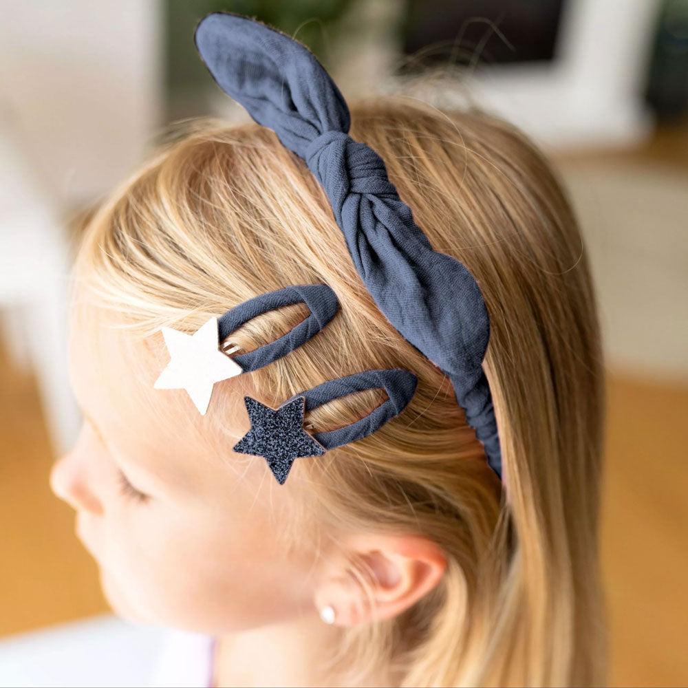 Haar-Accessoire-Set in der Farbe dunkelblau. Kind trägt Haarreif und zwei der Spängchen auf dem Set. 
