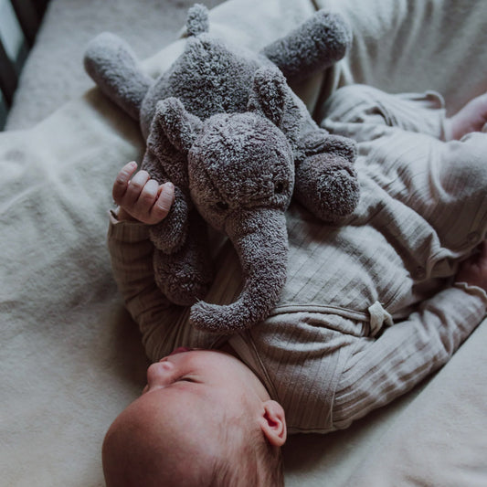 Baby kuschelt mit dem Heartbeat Comforter Elefant in grau