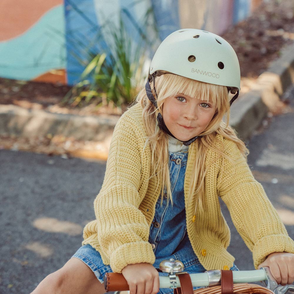 Mädchen auf dem Fahrrad trägt den Helm von Banwood in der Farbe Mint.