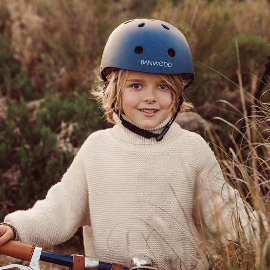 Junge trägt den Banwood-Helm in naviblue passend zu seinem Fahrrad.