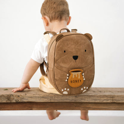 Rucksack für Kinder in braun in Form eines Bärs mit einem kleinen Honigtopf in den Händen
