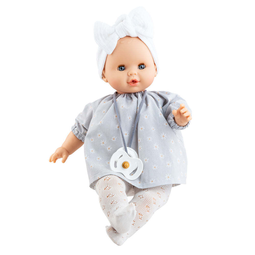 Puppe Sonia Daisy kommt mit einem hellblauen Puppenkleid mit zarten Gänseblümchen drauf. Zudem trägt sie eine weiße Lochstrumpfhose, ein weißes Stirnband und hat einen Schnuller um den Hals. 