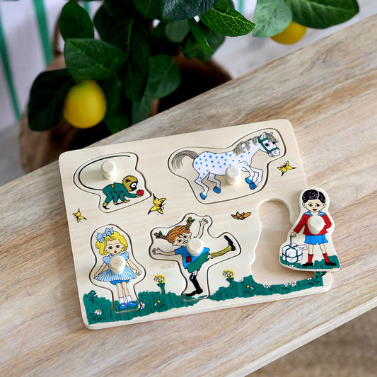 Das Holzpuzzle von Micki zeigt 5 Holzpuzzleteil mit Knopf zum einfachen Platzieren für die Kinder. Die Motive sind der Affe Herr Nilson, Kleiner Onkel, Annika, Tommy und Pippi Langstrumpf.