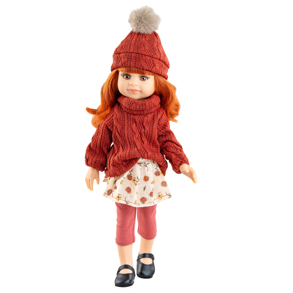 Puppe Amiga Cleo hat lange orangene Haare mit Pony, hellbraune Augen und trägt ein modernes Outfit mit Strickpulli und Bommelmütze. 