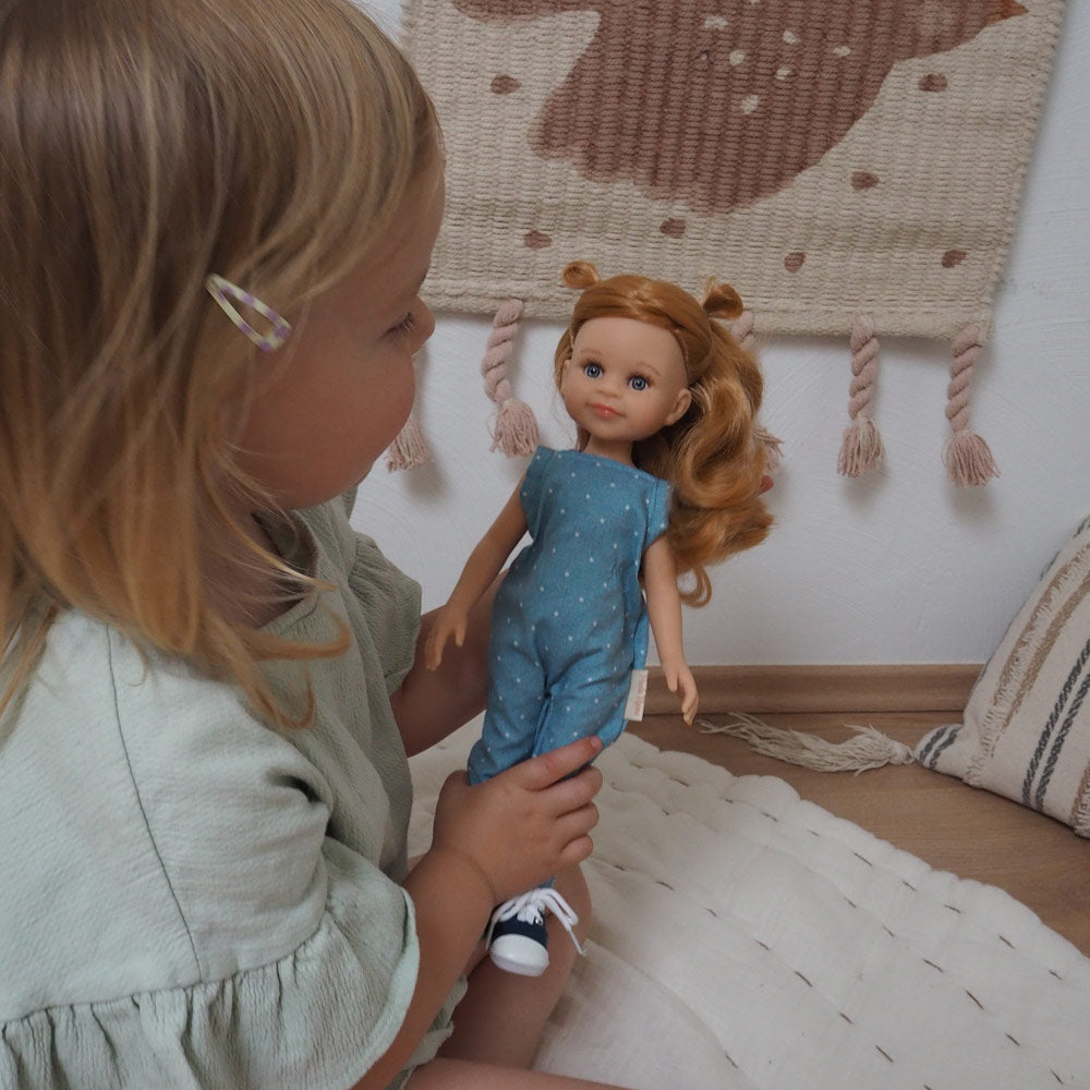 Mädchen spielt mit der Amiga-Puppe mit orangenen Haare und modernem Outfit 