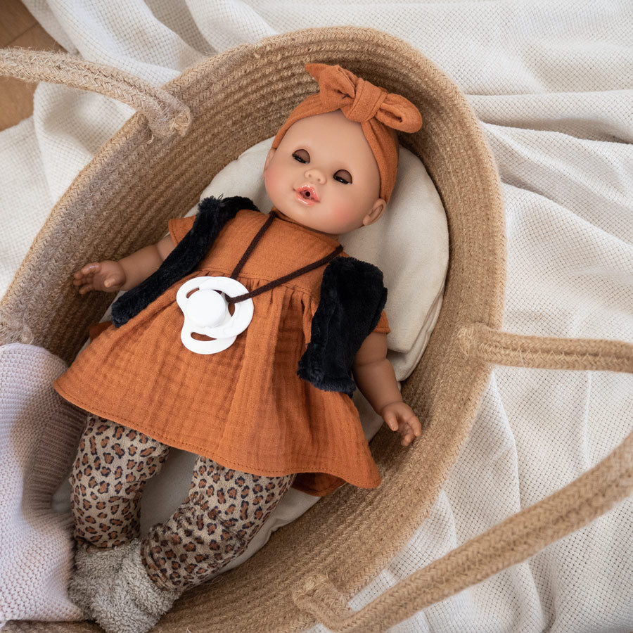 Puppe Sonia schließt die Augen, wenn man sie hinlegt. Hier liegt die Puppe in einem schönen Puppentragebett.