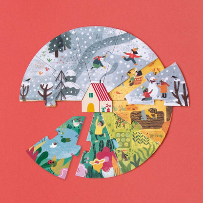 Jede Puzzleschicht zeigt eine Jahreszeit, Frühling, Sommer, Herbst oder Winter. In der Mitte steht ein kleines Haus. 
