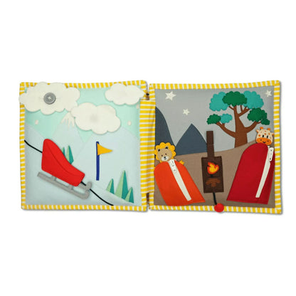 Schlitten, den die Kinder an einer Schnur den Berg runterfahren können. Die Wolke ist mit einem Knopf befestigt, mit dem die Kinder ihre Feinmotorik üben können. Auf der rechten Seite sind ein Löwe und eine Giraffe in jeweils einem Schlafsack zu sehen. Die Schlafsäcke kann man mit einem Reisverschluss öffnen. In der Mitte ist ein Lagerfeuer, das man mit einer Schnur an- und ausmachen kann. 