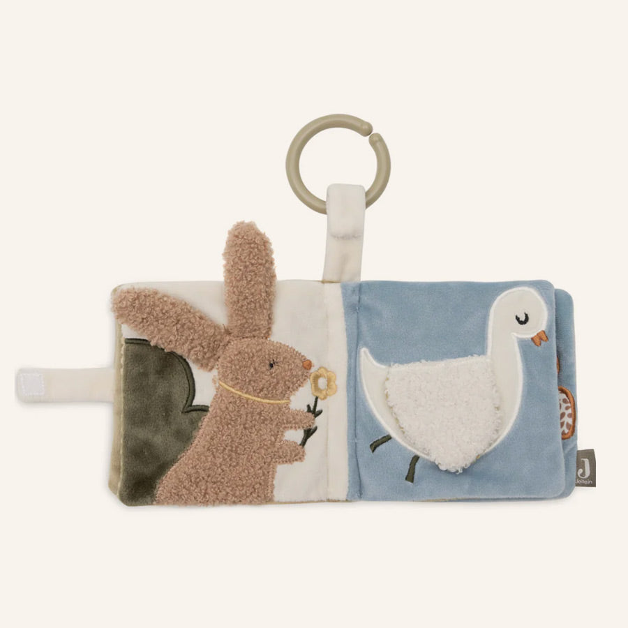 Kuscheliger Hase im Buch und eine süße weiße Ente mit kuscheligem Flügel