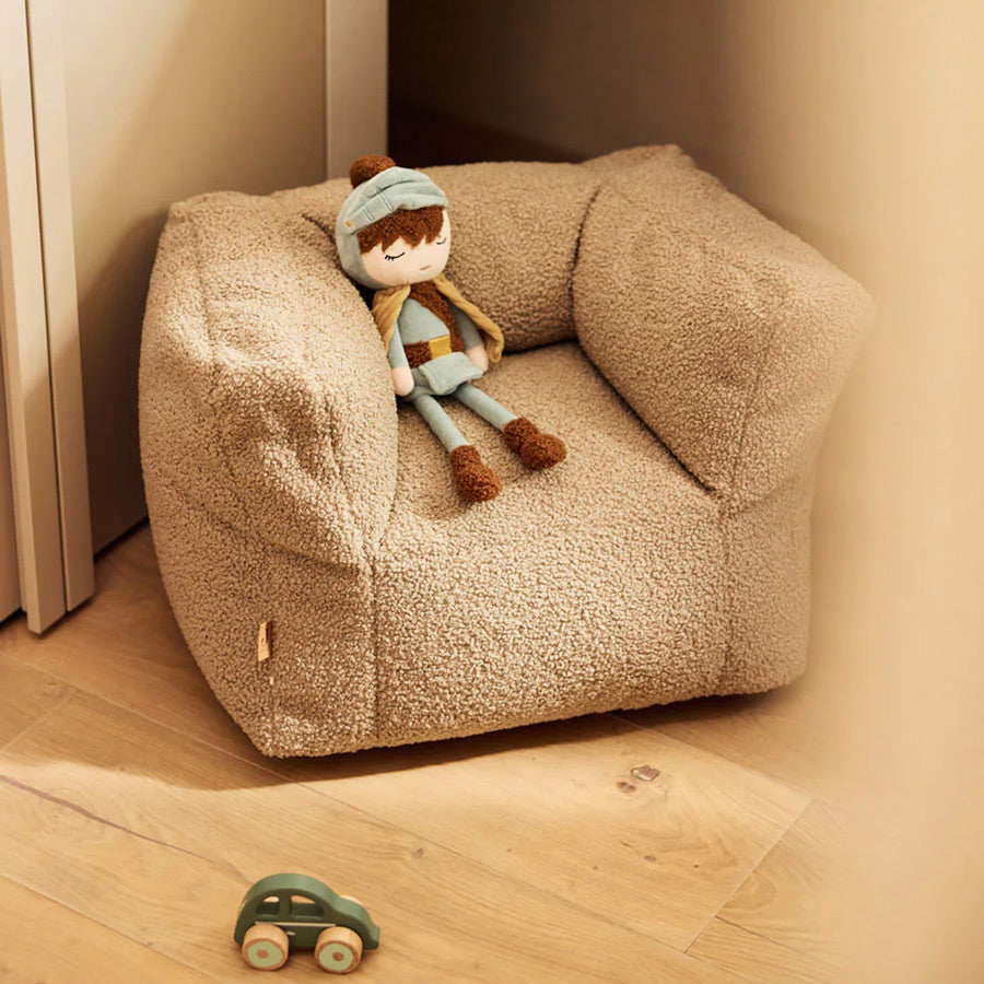 Stoffpuppe Ritter sitzt gemütlich auf einem Kindersessel