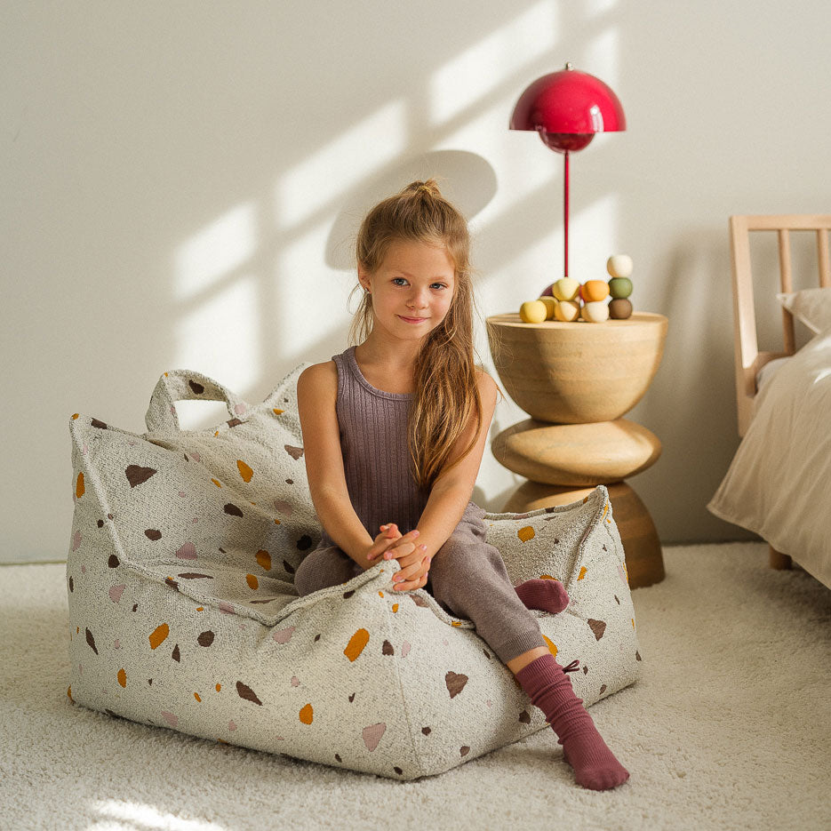 Mädchen sitzt auf dem Sitzsack in der Farbe marble 